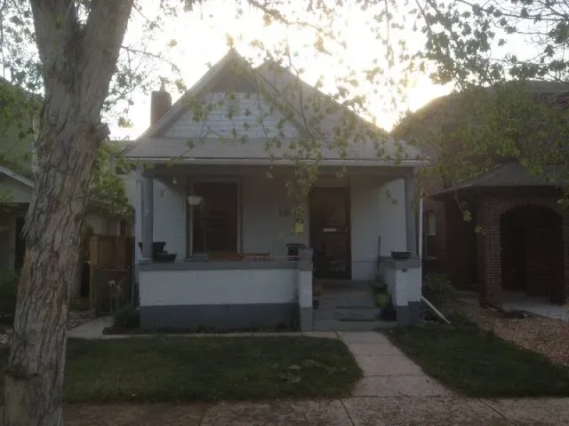 Exterior view of a small white bungalow home before major renovations by Positive Design Build.